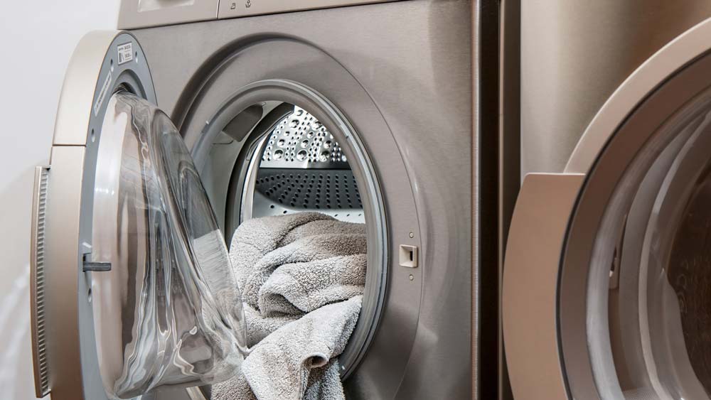 A dryer with the door open, full of clean laundry