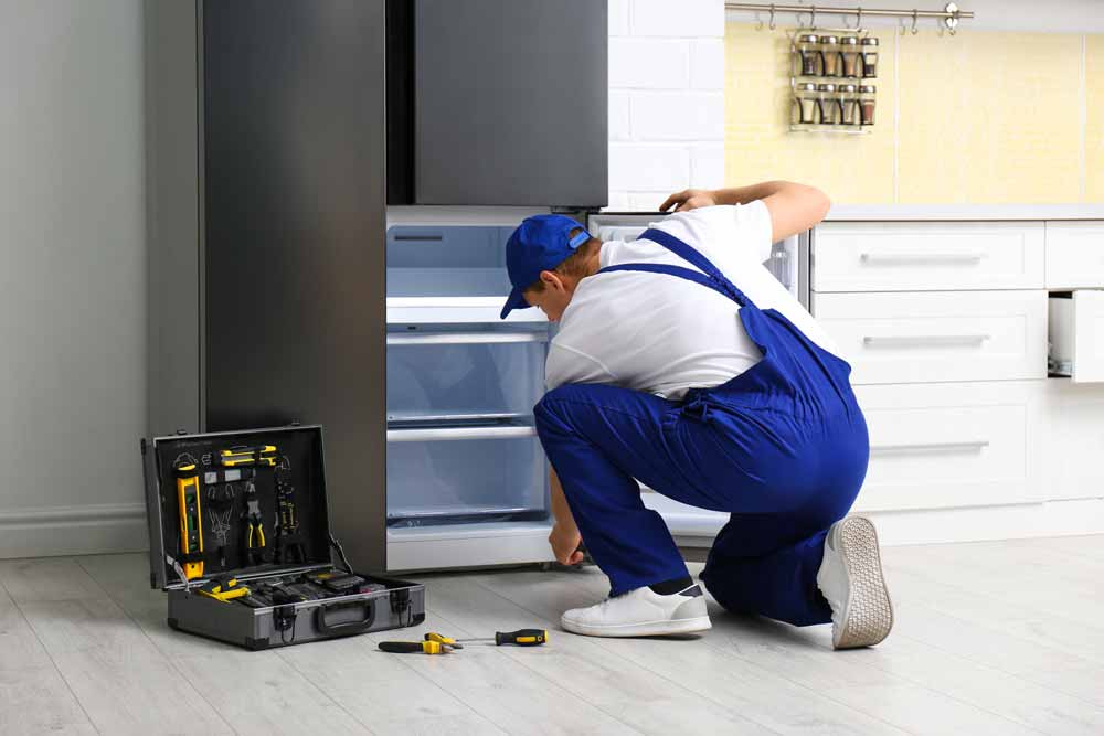 Repair technician fixing the freezer door on a refrigerator