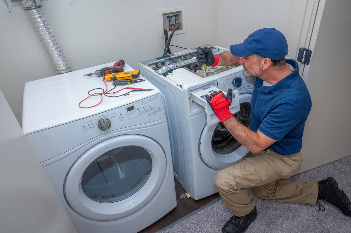 Appliance repair man repairing the detergent drawer on a washing machine